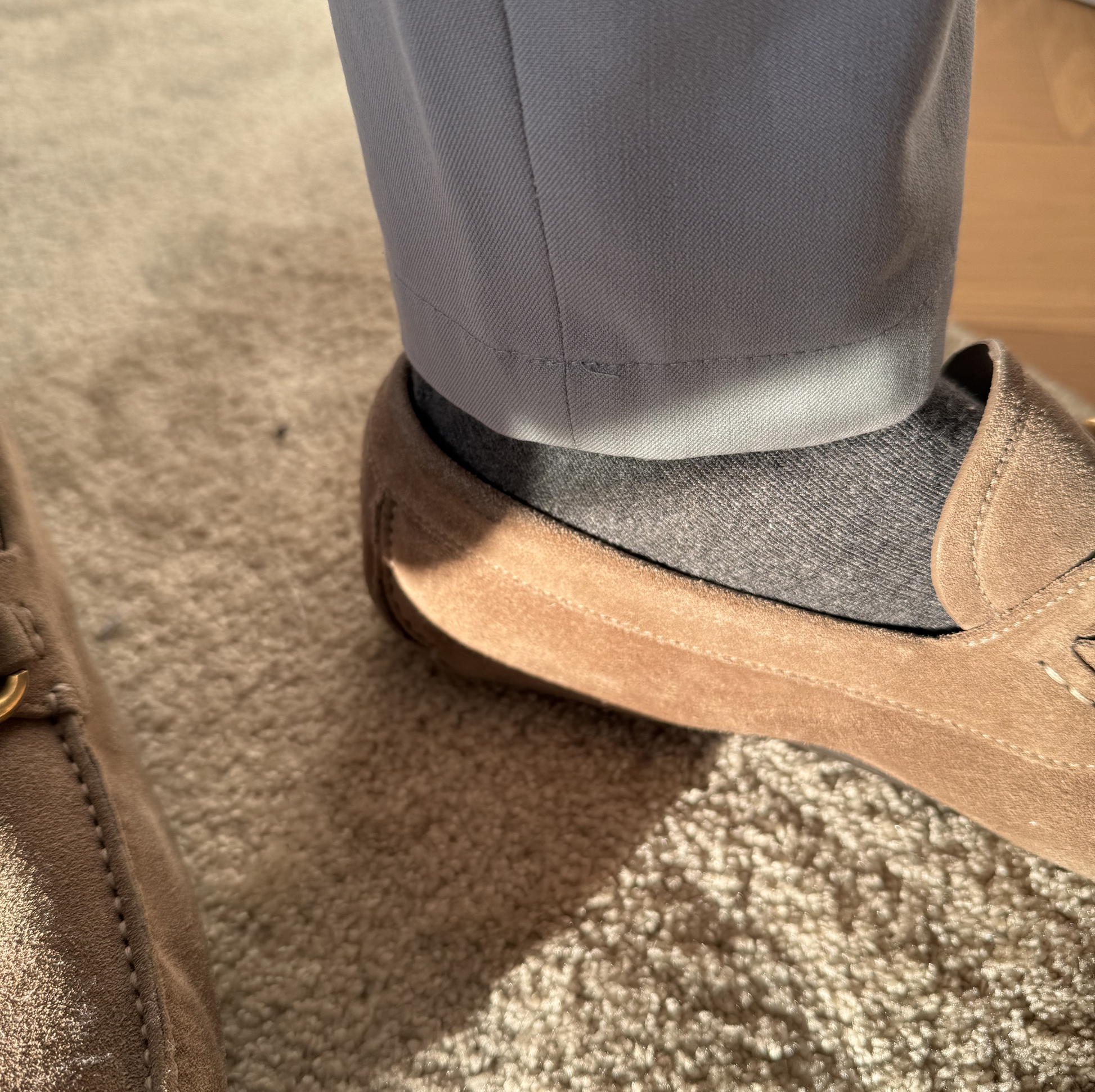 Main Copenhagen strømper – diskret elegance og luksus i ét. Her i klassisk grå og stylet med loafers og lyse bukser, som fremhæver strømpernes alsidighed og høje kvalitet. Perfekte til både kontor og café.