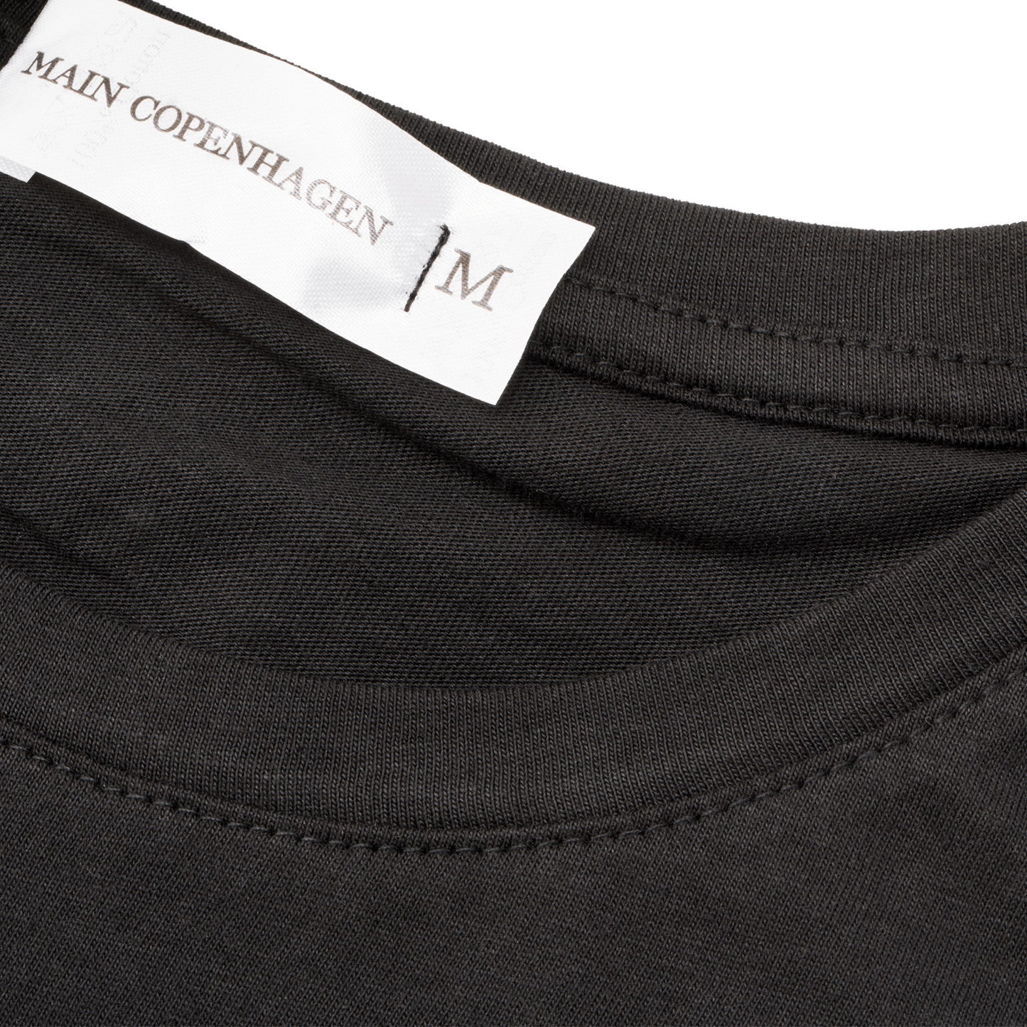 Diskret label med broderet logo – enkel, klassisk og komfortabel i nakken.